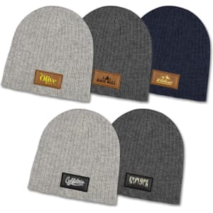 A collection of cable knit beanies in light grey, dark grey, navy, and olive, each with a unique patch.