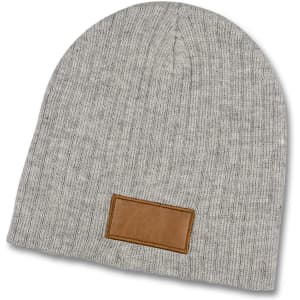 A grey cable knit beanie with a leather patch. The beanie has a soft, textured appearance.