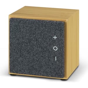 A bamboo Bluetooth speaker with a grey felt front, featuring simple volume controls and a modern cube design.