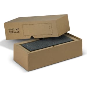 A grey Bluetooth speaker inside a stylish brown box with a minimalist design and a logo.