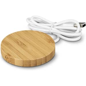A round bamboo wireless charger with a white USB cable. The charger features a smooth, natural wood finish.