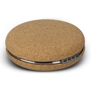 A circular compact mirror with a natural cork exterior and a stainless steel latch.