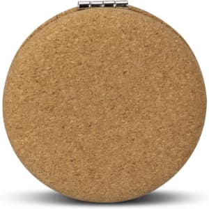 A round compact mirror with a natural cork exterior and a silver clasp.