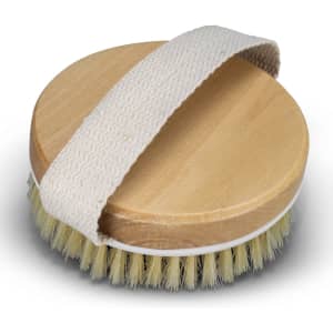 A round wooden body brush with a soft bristle edge and a fabric strap for grip.