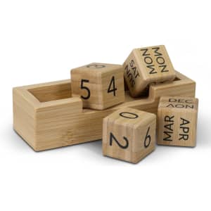 A bamboo desk calendar featuring wooden blocks with numbers and month names, presented in a matching bamboo holder.