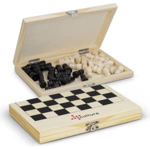 A wooden travel chess set featuring black and white pieces, housed in a checkered-patterned box with a logo.