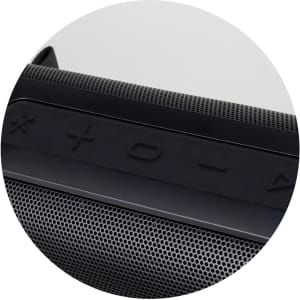 A close-up of a black Bluetooth speaker featuring control buttons and a textured grille.