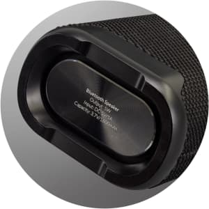 A black Bluetooth speaker with a textured exterior, featuring a silver output section and branding.