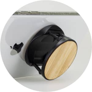 A bamboo phone holder with a black base, designed to securely hold smartphones.