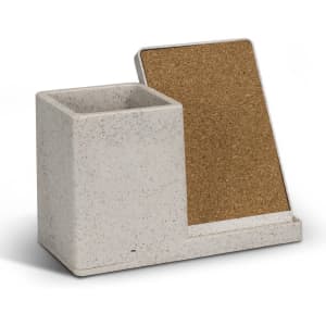 A speckled grey wireless charger desk caddy with a cork backing and compartment for holding small items.