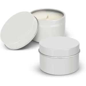 A set of two silver travel candles in metal tins, one with an open lid revealing a cream-coloured wax.