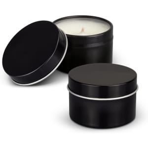 A black tin candle container with a lid, featuring a white candle inside. Another matching black tin is beside it.