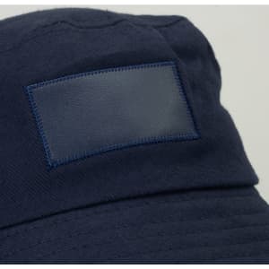 A navy bucket hat featuring a patch area and a logo. Ideal for headwear with a wide brim.