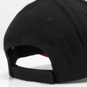 A black cap with a red interior, featuring a logo and an adjustable strap at the back.