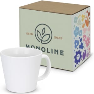 A white coffee mug next to a decorative box with a floral design and branding elements.