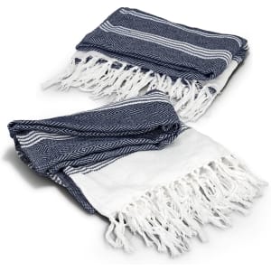 A navy and white throw blanket with a herringbone pattern and fringed edges. It is neatly folded.