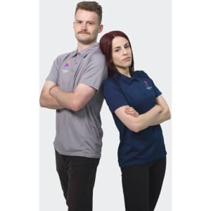 A grey men's polo and a navy women's polo, each with a logo. Both models are standing back-to-back with arms crossed.