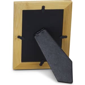A wooden photo frame in a natural finish, featuring a sturdy stand and a backing panel. It has a logo.