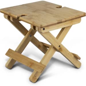 A folded bamboo wine table featuring a natural finish and crossed legs, designed for outdoor leisure activities.