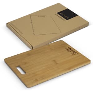 A bamboo chopping board in a rectangular shape, placed near its eco-friendly packaging. The board features a handle.