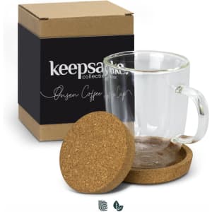 A glass coffee mug with a handle, accompanied by a cork coaster, in a box featuring a logo.