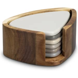 A triangular wooden coaster holder presents a set of five pebble coasters in earthy tones.