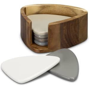 A wooden holder contains a set of four triangular coasters in grey and white tones.
