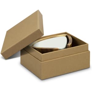 A set of pebble-shaped coasters in a cardboard box, featuring a light green top and a wooden base.