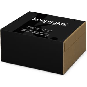 A black and brown box containing the Keepsake Pebble Coaster Set, featuring a logo on the front.