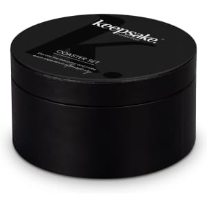 A black round box containing a coaster set, featuring a logo on the top.