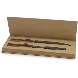 A wooden keepsake carving set in a brown gift box with two knives and protective sheaths.