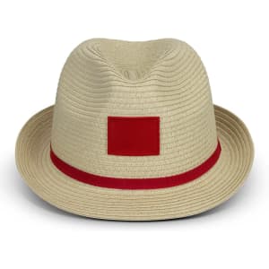 A cream fedora hat with a red band and a square patch, featuring a textured design.