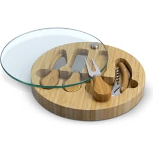 A bamboo cheese board with a glass top, featuring three cheese utensils and a corkscrew.