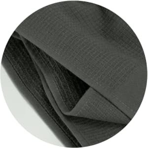 A dark grey waffle towel with a textured surface, featuring a folded design. It has a branding logo.