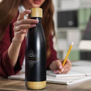 A drink bottle featuring a black body and bamboo accent, with a logo on the front.