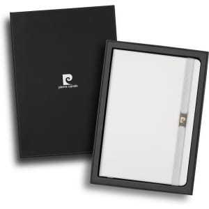 A white notebook in a black gift box, featuring a branding logo and a closure strap.