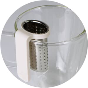 A glass cup with a white handle and a stainless steel infuser attached, designed for loose tea brewing.