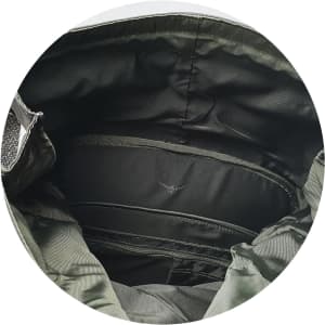 An interior view of a green Osprey Arcane Roll Top Backpack, showcasing its storage compartments and lining.