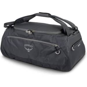 A black duffle bag with dual handles and a logo. Features an external pocket and a durable design.