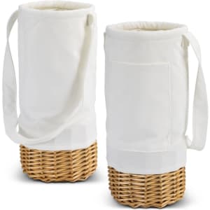A white fabric wine carrier with a wicker base and a shoulder strap, featuring a side pocket.