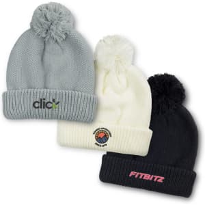 Three beanies in grey, white, and black with pom-poms, each featuring a logo on the front.