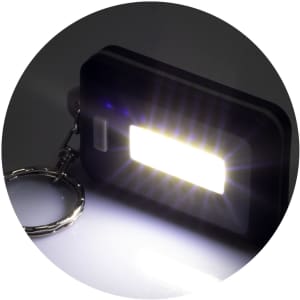 A black key ring light with a rectangular LED panel, emitting a bright white light. It features a metal keychain.