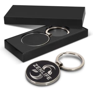 A round silver key ring with a leather centre, presented in a sleek black gift box.