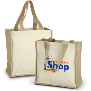 A natural canvas tote bag with tan handles and a logo on the front. Designed for shopping and carrying items.