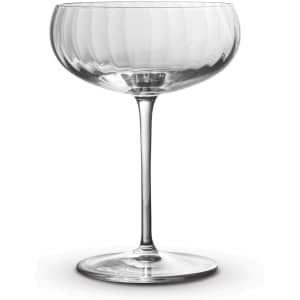 A clear glass cocktail glass with a ribbed design and a long stem, featuring a smooth, elegant bowl.