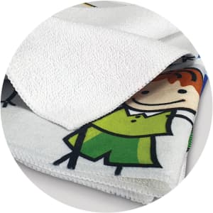 A vibrant, full-colour tea towel featuring playful cartoon designs, predominantly in white, green, and yellow shades.