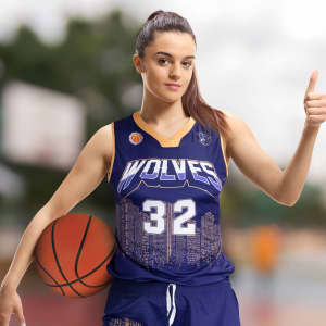 A women's basketball top in navy blue with a city skyline design and a logo, worn by a model holding a basketball.