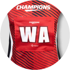 A red netball bib with black stripes, featuring a large white "WA" and a logo.