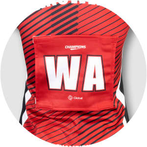 A red netball bib featuring bold stripes and a pocket for a number, with a logo present.