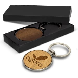 A round wooden key ring with a silver metal keychain, presented in a black box. Features a logo on the wood.